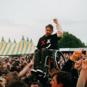 A fan in a wheelchair is lifted up by the crowd during Sum 41's set at Slan Dunk Festival South in Hatfield Park.