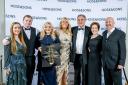 Cosmo Lloyd (third from right) and Keeta Thomas (third from left), Joint Owners of Henlle Hall Woodland Lodges and members of the team receive the park’s award from Gemma Brown, General Manager at Hoseasons